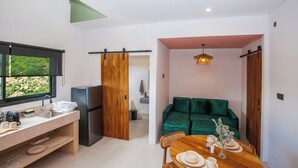 Une cuisine moderne équipée d’un réfrigérateur, d’un évier et d’un coin repas avec une table dressée pour deux personnes.