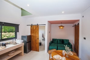 A modern kitchen with a refrigerator, sink, and dining area with a table set for two.