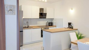 A modern kitchen with white cabinets, a wooden countertop, a built-in oven, and a microwave. - Apartment With Balcony And Parking 1, Okrug Gornji, Croatia (Okrug Gornji)