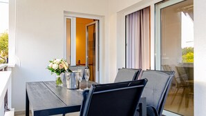 A balcony with a table set for two, a vase with flowers, and a bottle of champagne. - Apartment With Balcony And Parking 1, Okrug Gornji, Croatia (Okrug Gornji)