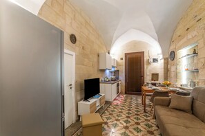 A compact living space with a kitchenette, a dining area, and a seating area. - NonnAnna Apartment In Martano Historic Centre, Martano, Italy (Martano)