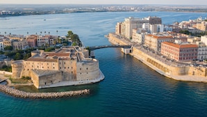A coastal cityscape with a prominent historical fortification, modern buildings, and a clear view of the sea. - Masseria Le Mesolecchie, Crispiano, Italy (Crispiano)