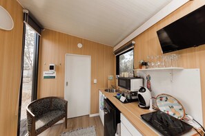 Ett litet, praktiskt pentry med mikrovågsugn, vattenkokare och ett litet kylskåp.