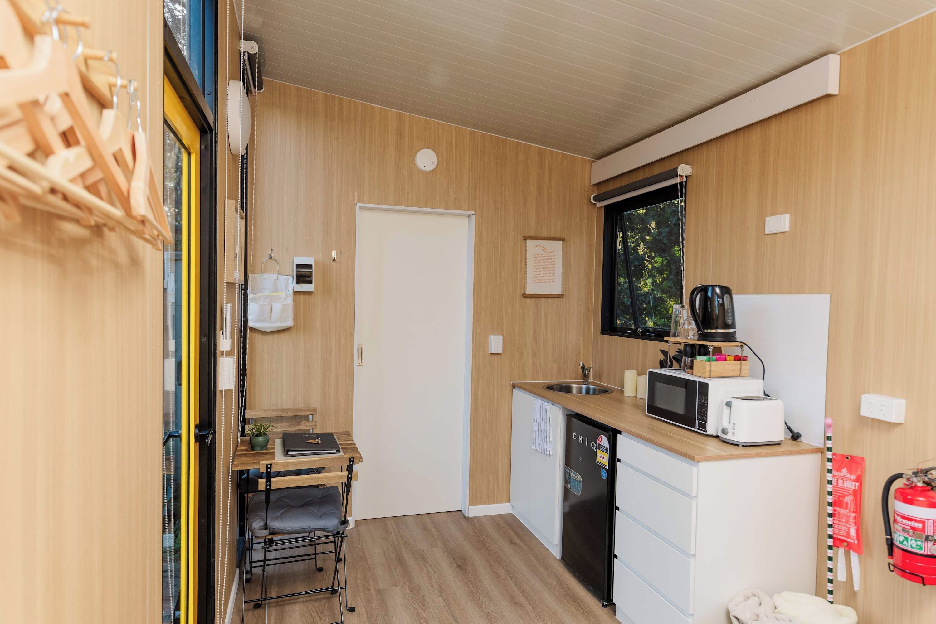 A compact kitchen with a microwave, toaster, and sink.
