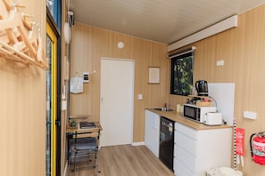 Cocina compacta con microondas, tostadora y lavabo.