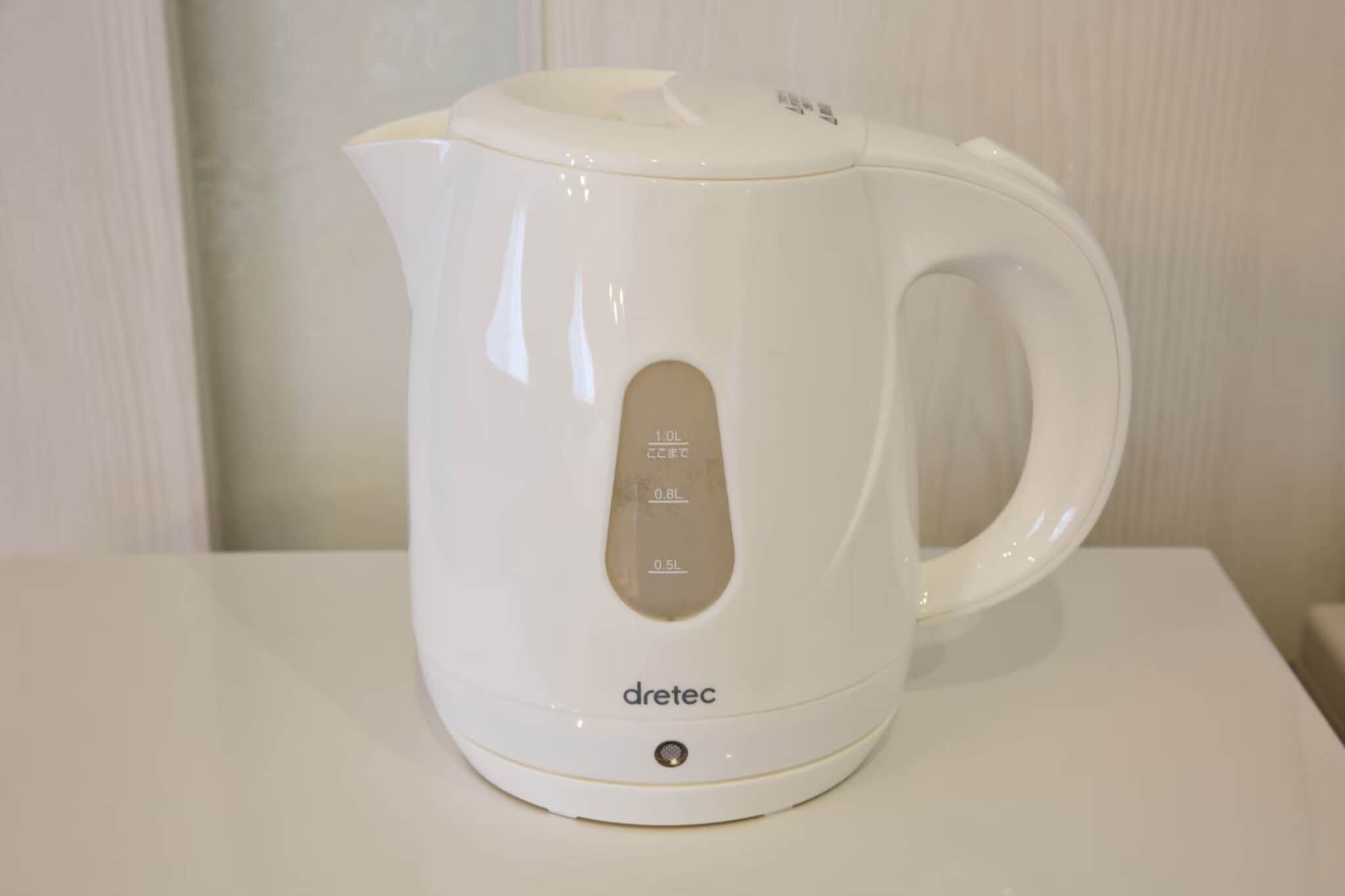 A white electric kettle with measurement markings and the brand 'dretec' on a white surface.