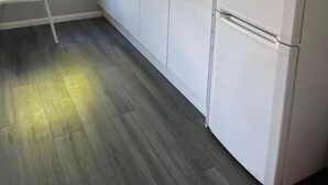 A modern kitchen with white cabinetry, a black countertop, and a built-in refrigerator. - Bright Double Room in Croydon Free Street Parking (London)