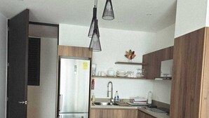 Uma cozinha moderna com ilha central, armários de madeira e uma área de refeições com mesa redonda e cadeiras.