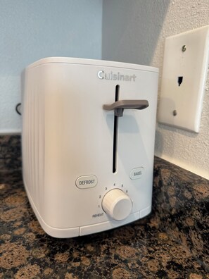 A white Cuisinart toaster with a defrost and bagel setting, placed on a granite countertop. - Nice 2-bedroom house with AC in welcoming Houston neighborhood (Houston)
