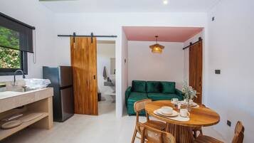 Eine moderne Küche mit Kühlschrank, Holzschränken und einem Essbereich mit Tisch und Stühlen.
