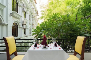 Mesa para dos con vista a un edificio y follaje.