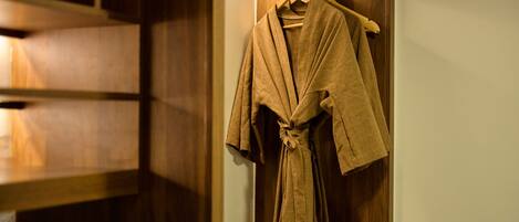 A wooden wardrobe with a robe hanging on a hanger.