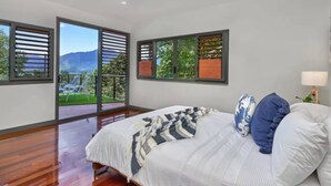 A bedroom with a bed, a ceiling fan, and a view of a balcony. - Luxury 3 bedroom Villa with Private Pool Views (Edge Hill)