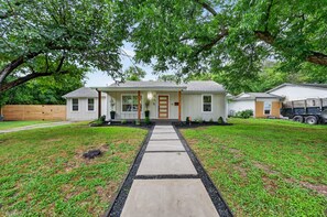 A single-story house with a front porch, a driveway, and a well-maintained lawn. - Executive 3BR Home, King Suite, Near Hospitals & Historic Downtown Mansfield (Mansfield)