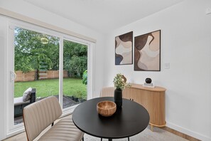 A modern room with a round table, a black vase, and abstract wall art. - Executive 3BR Home, King Suite, Near Hospitals & Historic Downtown Mansfield (Mansfield)