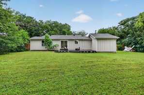 Ein eingeschossiges Haus mit überdachter Veranda, kleinem Vorgarten und Garage.