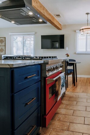 A kitchen with a built-in stove, a red oven, and blue cabinetry. - Charming Retreat in ABQ's North Valley-close to Old Town and Balloon Fiesta Park (Albuquerque)