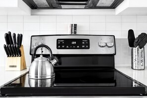 A kitchen with a stainless steel stove, a kettle, and a knife block. - City Views 2BR | Floor-to-Ceiling Windows A56 *1Bed* (Birmingham)