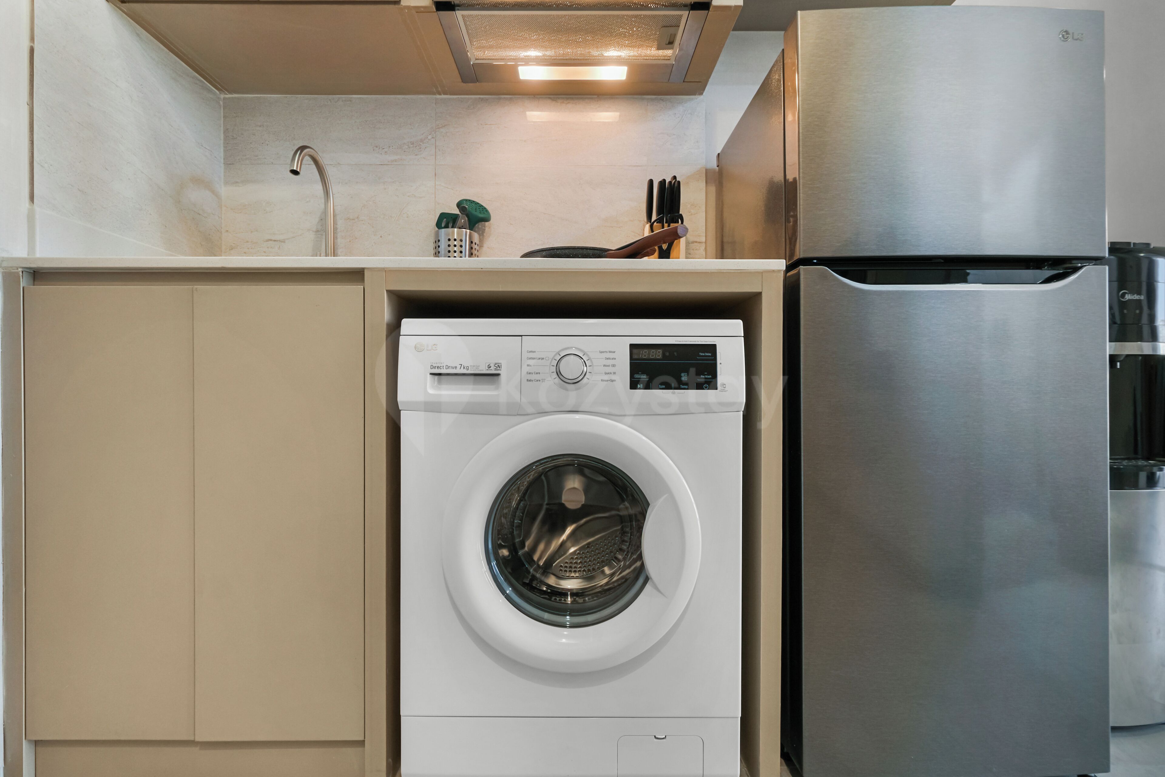 A compact kitchen with a built-in washer and refrigerator.