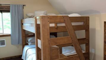 A bunk bed with a wooden frame in a room with a sloped ceiling.
