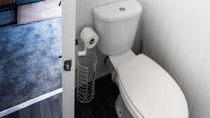 Ein kleines, kompaktes Badezimmer mit Toilette, Duschwanne und integriertem Bidet.