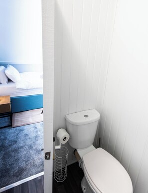 Ein kleines, kompaktes Badezimmer mit Toilette, Duschwanne und integriertem Bidet.