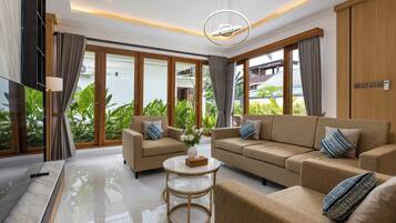 A modern living room with a sofa set, a coffee table, and a TV.