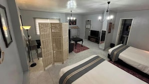 A hotel room with two beds, a desk, a chair, a television, and a wardrobe. - Sunbloom Beach Resort (Candelaria)