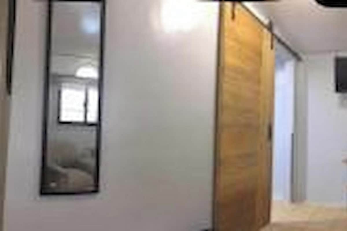 A hotel room with a bed, a TV, and a window.
