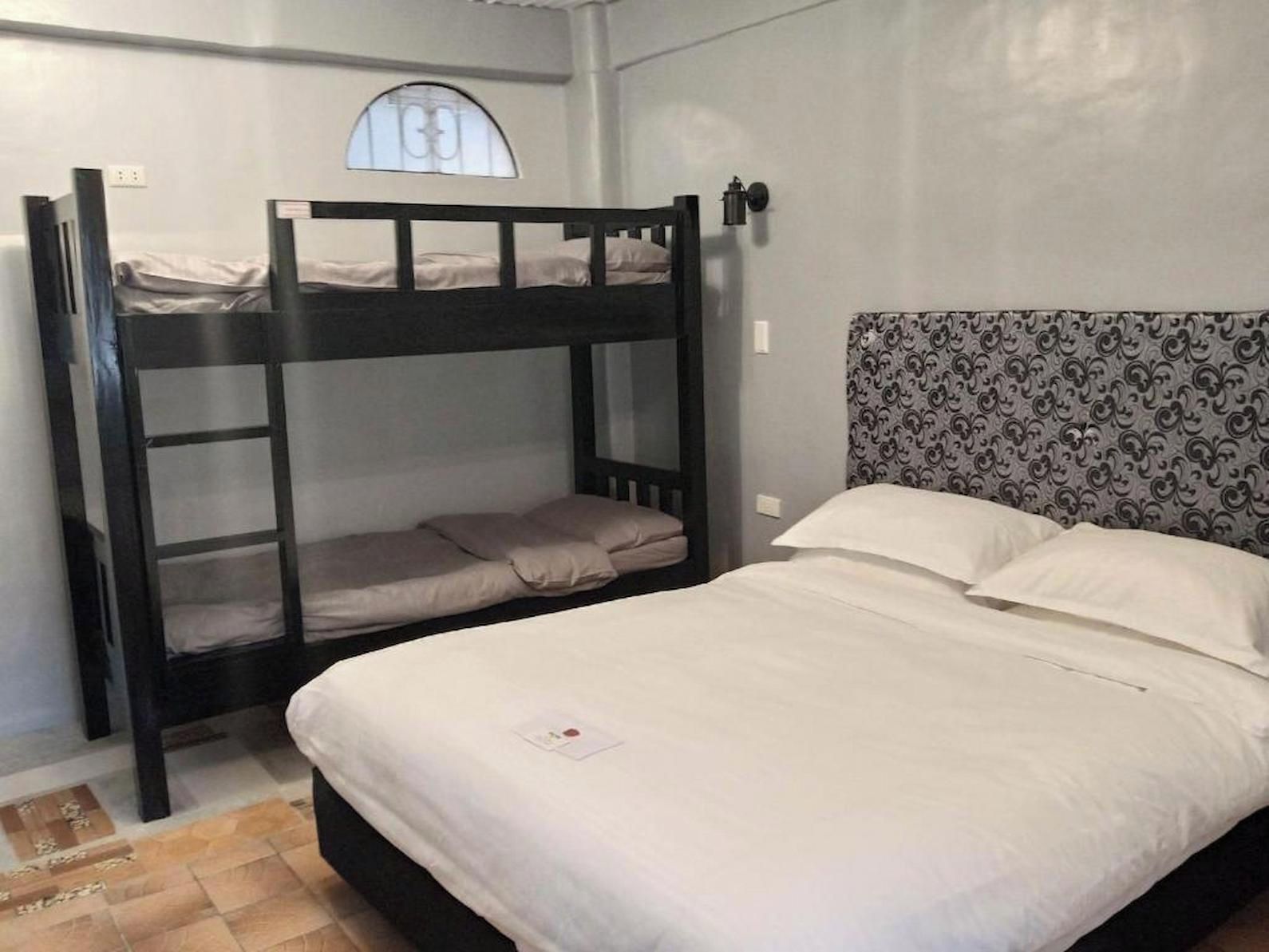 A bunk bed with a lower bunk and a single bed, both with white bedding.