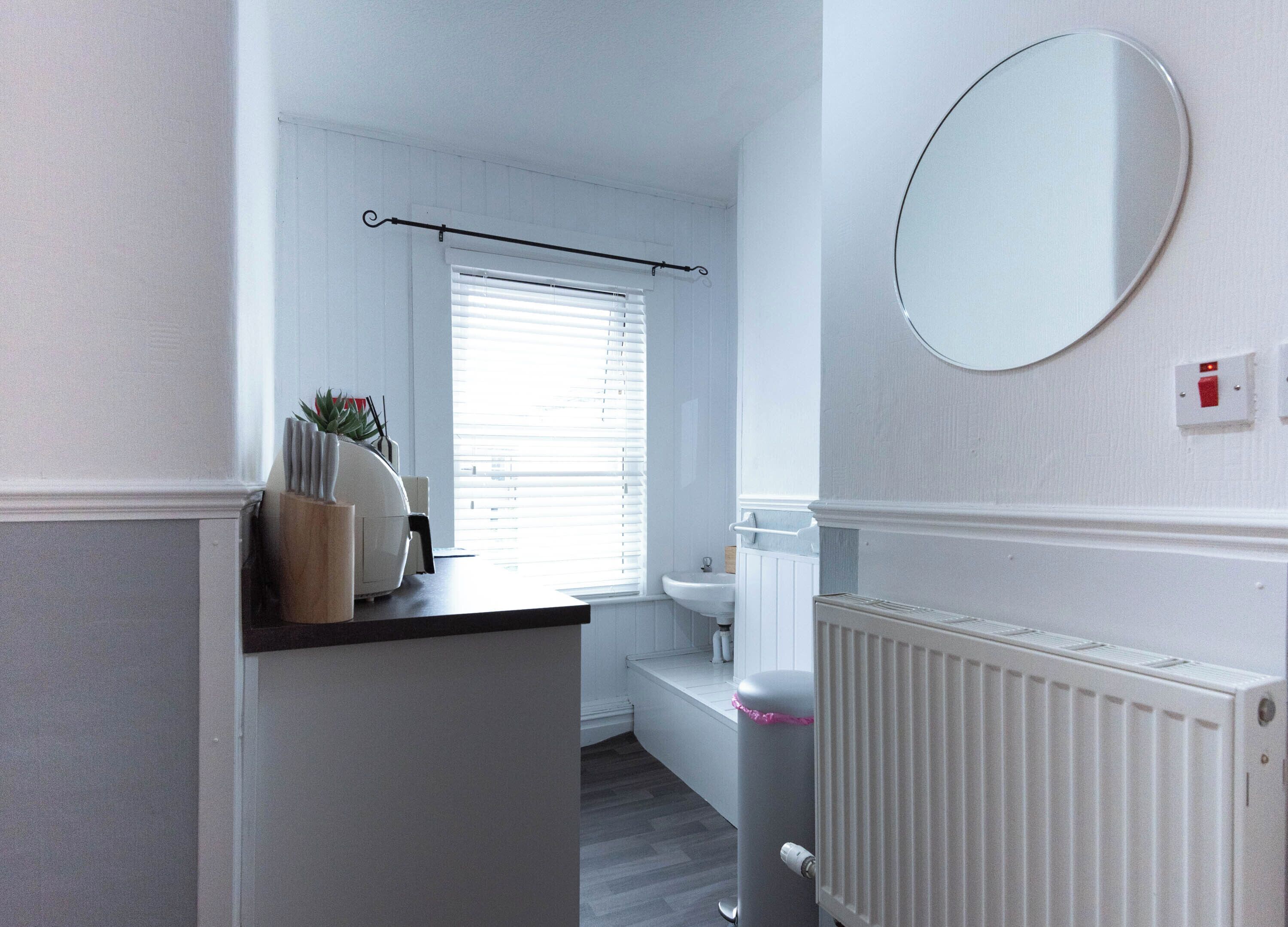 Ein Badezimmer mit Toilette, Waschbecken und einem Fenster mit Jalousien.