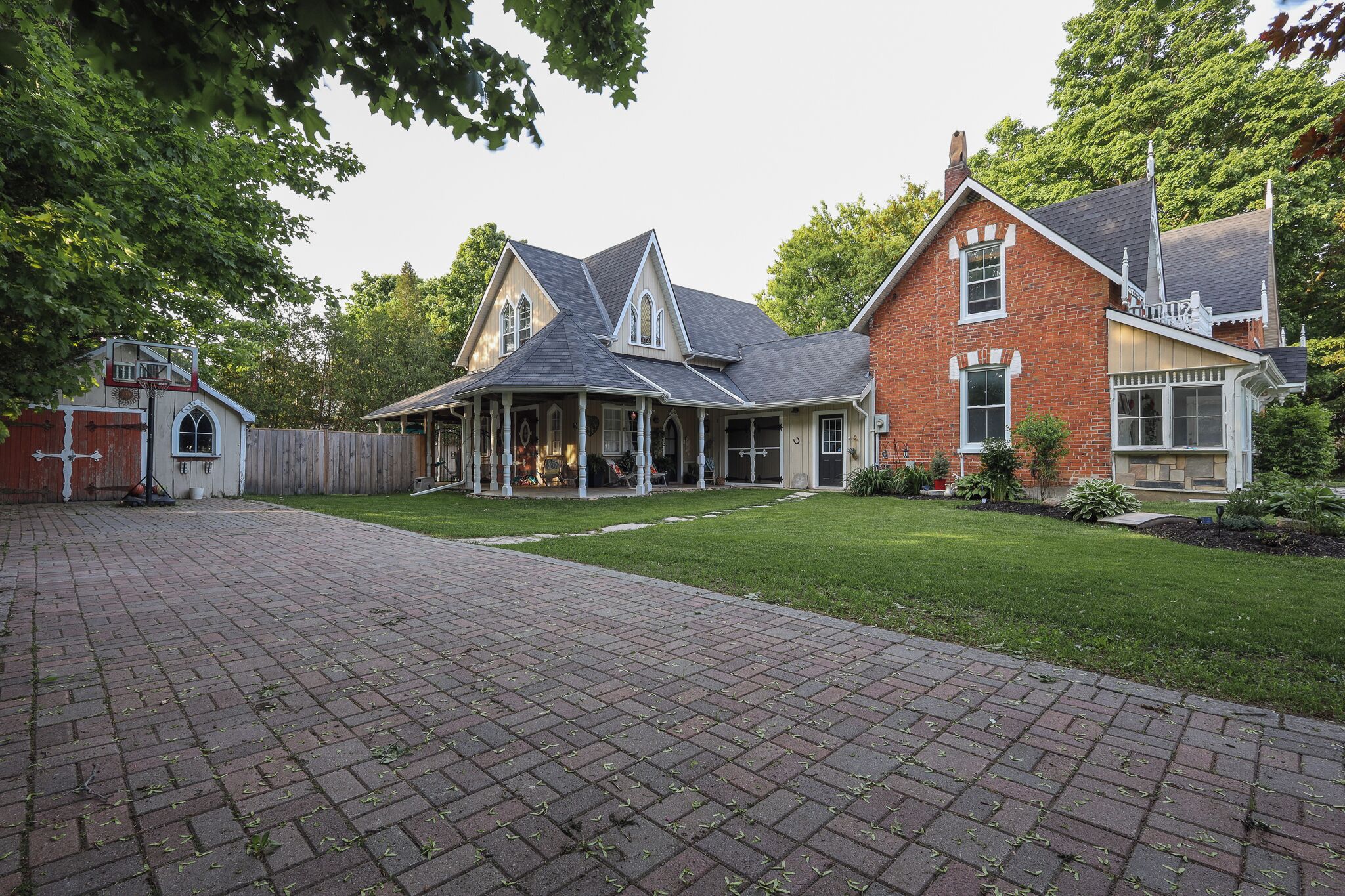 A two-story house with a brick exterior, a front porch, and a well-maintained lawn.