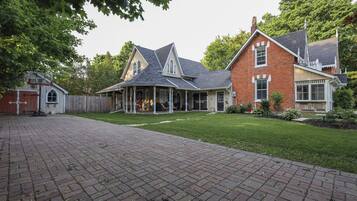 A two-story house with a brick exterior, a front porch, and a well-maintained lawn.