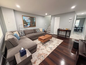 A modern living room with a sectional sofa, a coffee table, and a rug. - Furnished Half-Duplex in Newark’s West Side - Gated, Secure & Move-In Ready (Newark)