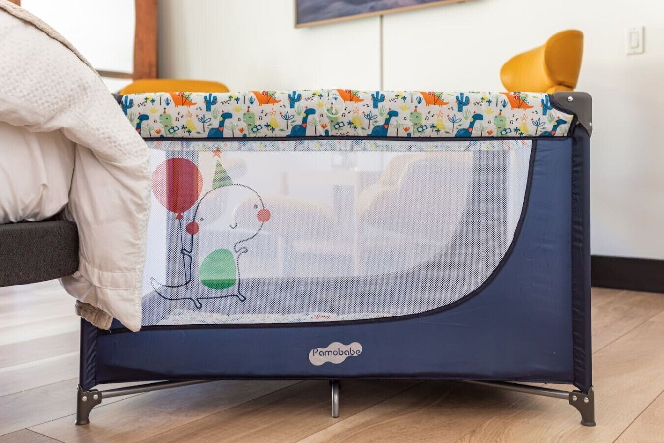 A baby playpen with a colorful top and a cartoon character design.