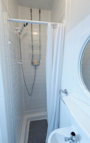 A small, white bathroom with a shower, a toilet, and a sink. - The Bay Apart-Hotel by Guestz (Morecambe)