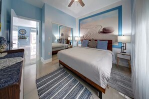 A hotel room with a large bed, a bedside table, a nightstand, a mirror, and a ceiling fan. - Tranquility 2Bed/2Bath/2K -5 Star DT Area -Hot Tub (Fort Lauderdale)