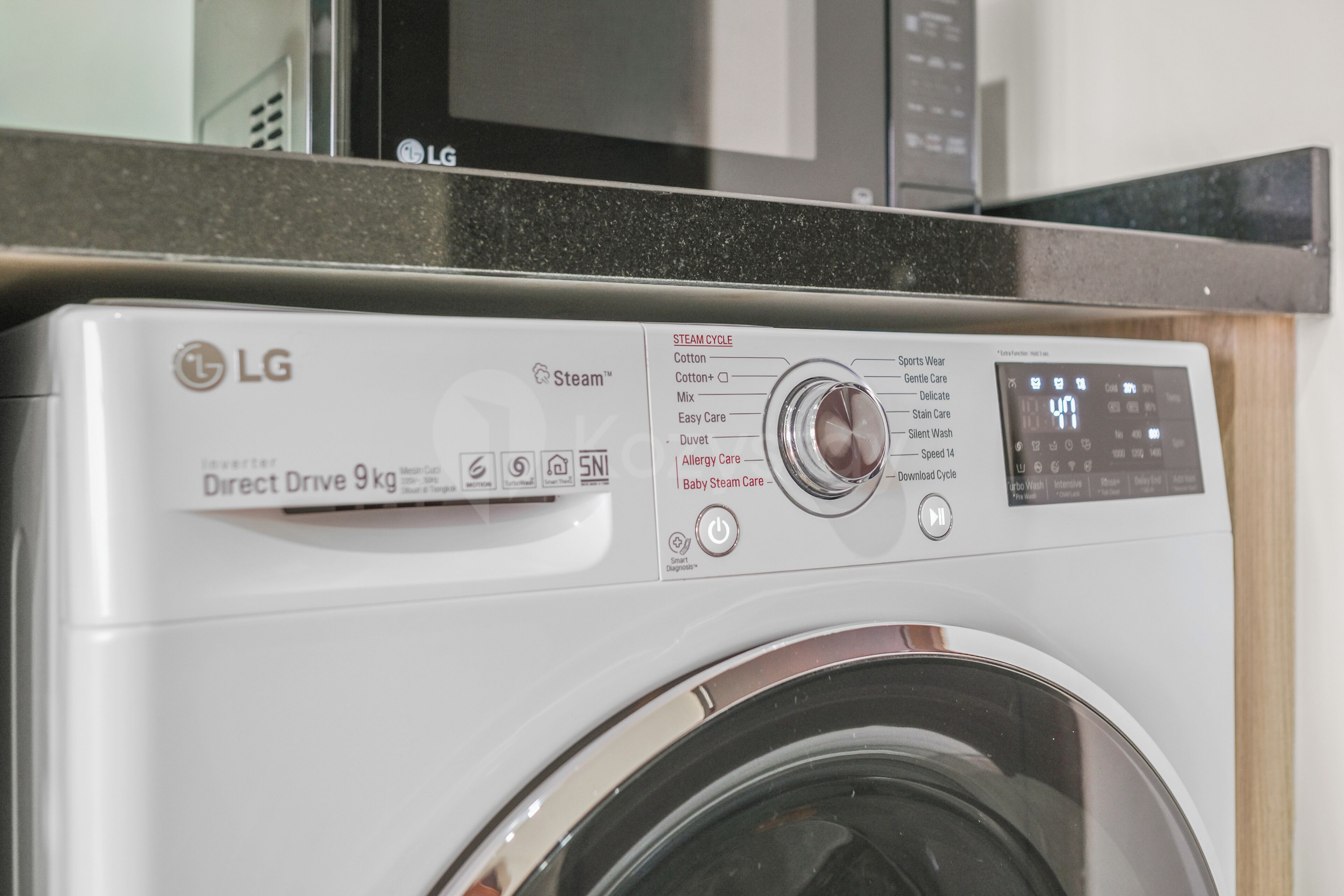 A white LG Direct Drive 9 kg washing machine with a control panel displaying various settings.