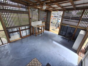 Une pièce avec un sol en béton, un lavabo et un banc en bois.