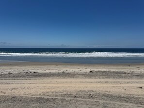 A beach with waves, clear sky, and distant land. - Family Beachside Haven: 2BR + Twin Room -2 Full Baths -Steps to Surf (Imperial Beach)