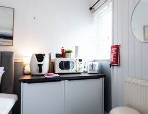 A kitchenette with a microwave, toaster, and coffee maker. - The Bay Apart-Hotel by Guestz (Morecambe)