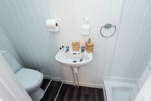 A bathroom with a toilet, sink, and shower. - The Bay Apart-Hotel by Guestz (Morecambe)