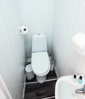 A small, compact bathroom with a toilet, bidet, and a sink. - The Bay Apart-Hotel by Guestz (Morecambe)