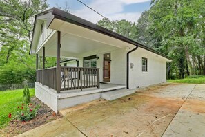 A single-story house with a covered porch, a small front yard, and a driveway. - Delightful 3-bedroom house with AC in charming Decatur (Decatur)