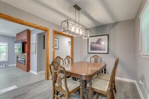 A dining area with a wooden table and chairs, a chandelier, and a fireplace. - Delightful 3-bedroom house with AC in charming Decatur (Decatur)