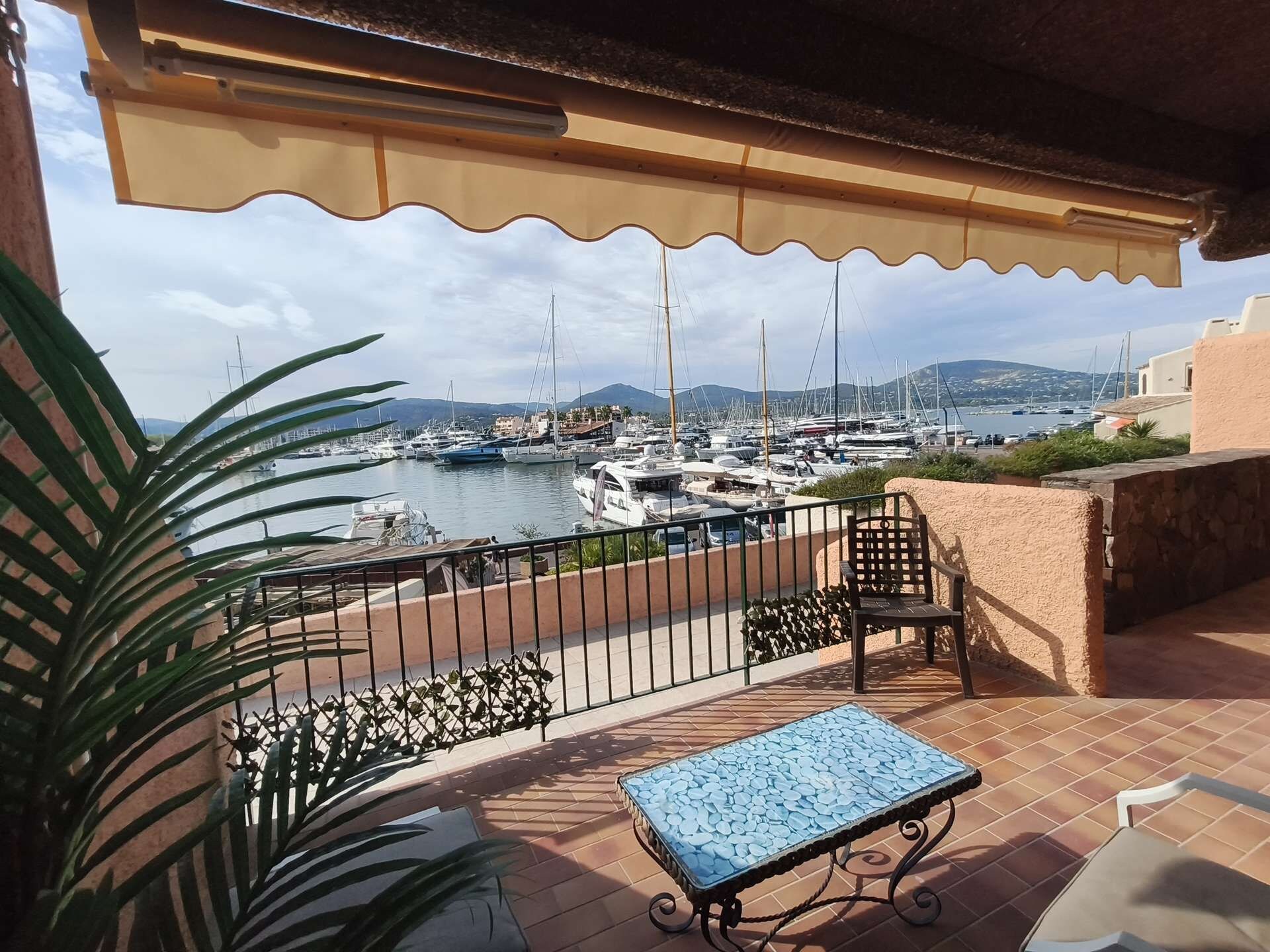 Uma varanda com vista para uma marina, uma mesa e uma cadeira.