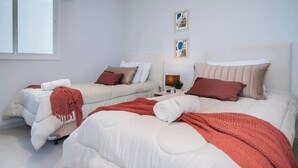 A hotel room with two beds, a window, and artwork on the wall. - Corporate Stays First Living - 403 (Asunción)
