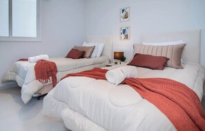 Ein Hotelzimmer mit zwei Betten, einem Fenster und Bildern an der Wand.