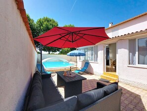 A pool area with a hot tub, outdoor furniture, and a red umbrella. - L Escapade Orangeoise by Interhome (Orange)