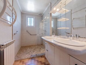 Baño con dos lavamanos, ducha y ventana.